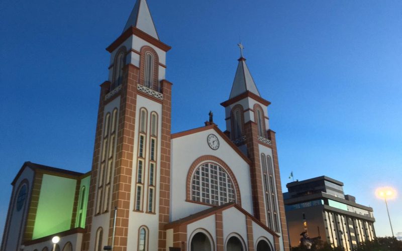 Catedral de Chapecó ao anoitecer, com suas duas torres iluminadas.