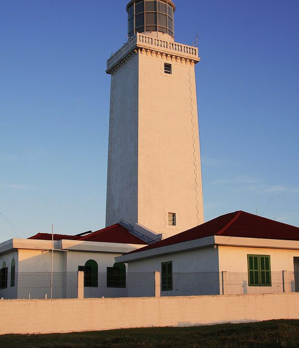 Farol antigo à beira-mar em dia de céu nublado, na cidade de Laguna.