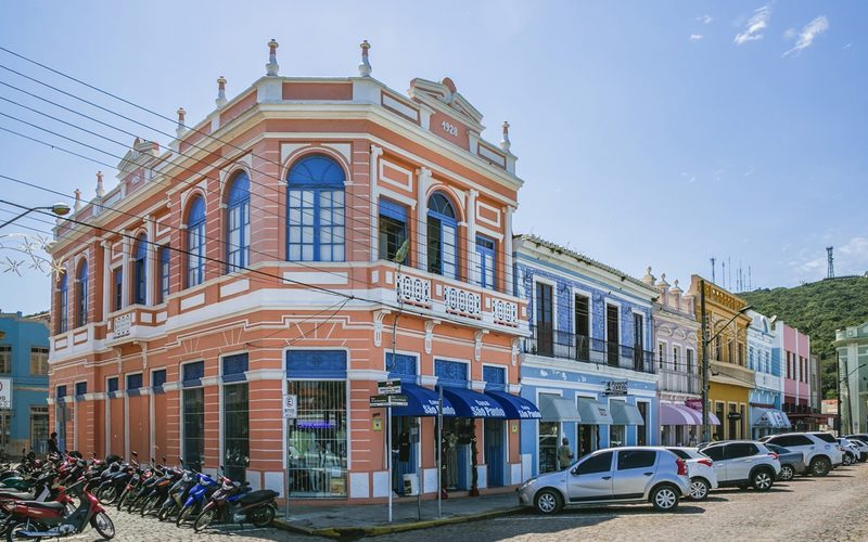 Casario colonial colorido de Laguna com o mar visível ao fundo.