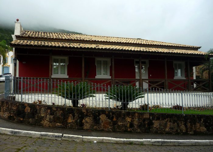 Casario colonial branco com portas e janelas azuis, típico da arquitetura açoriana do litoral catarinense.